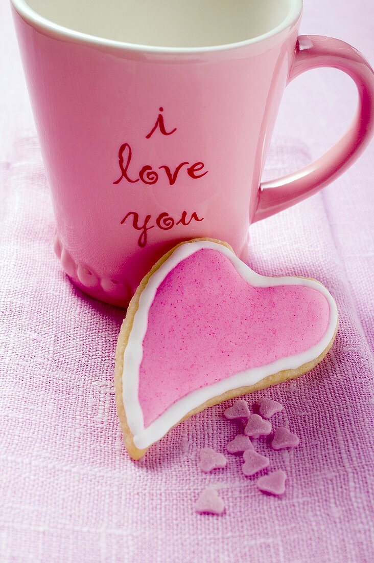 Heart-shaped biscuit in front of mug with the words 'I love you'