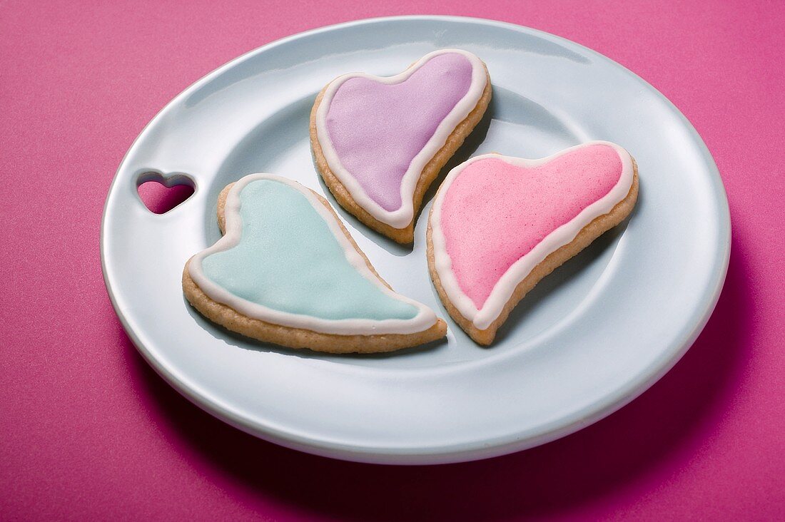 Drei herzförmige Plätzchen mit Zuckerglasur zum Valentinstag