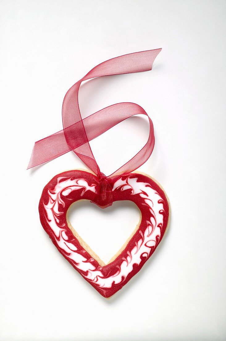 Herzförmiges Plätzchen mit roter Schleife zum Valentinstag