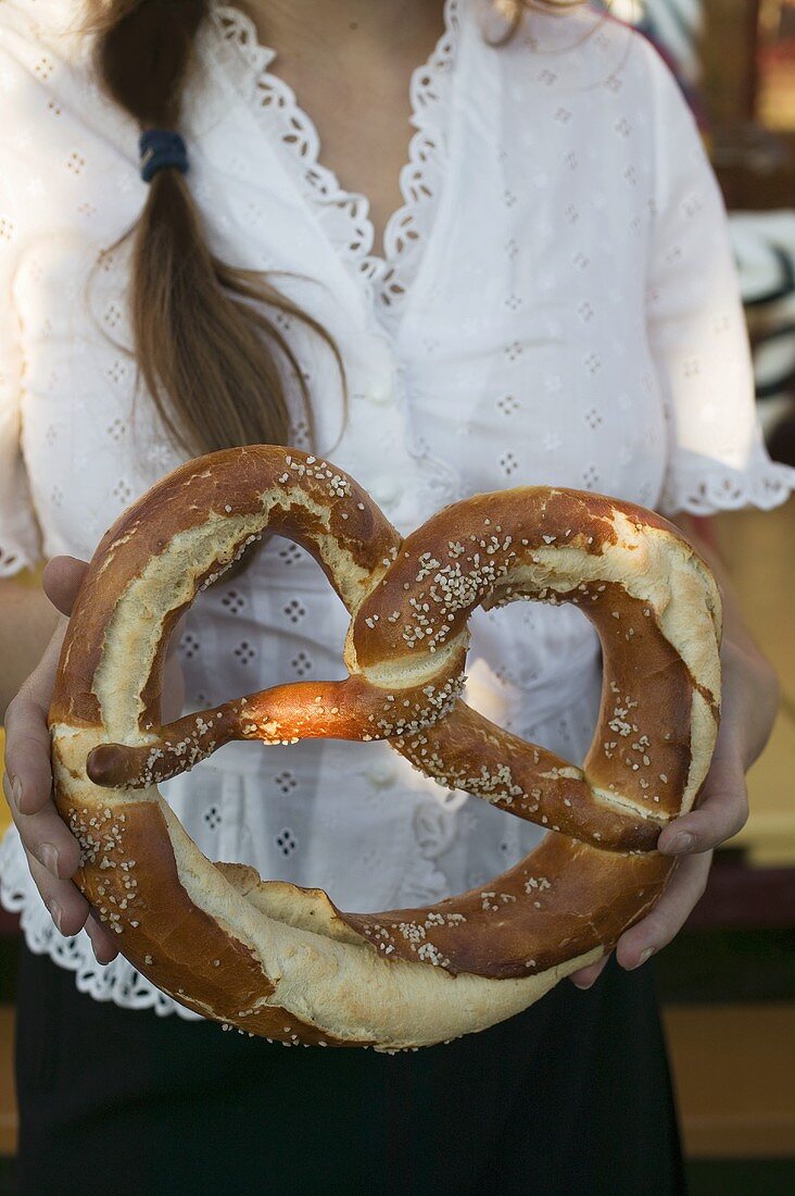 Woman holding giant pretzel at Oktoberfest
