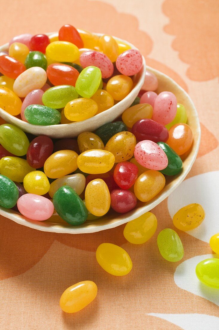 Coloured jelly beans in and beside two bowls