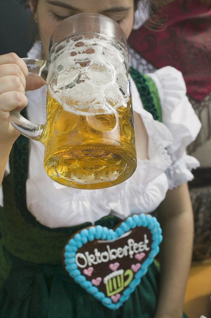 Woman drinking litre of beer at Oktoberfest