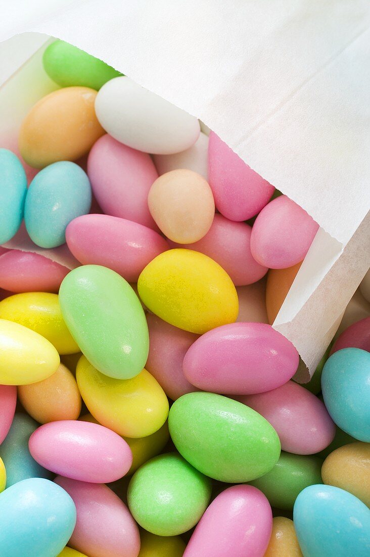 Sugared almonds, some in paper bag