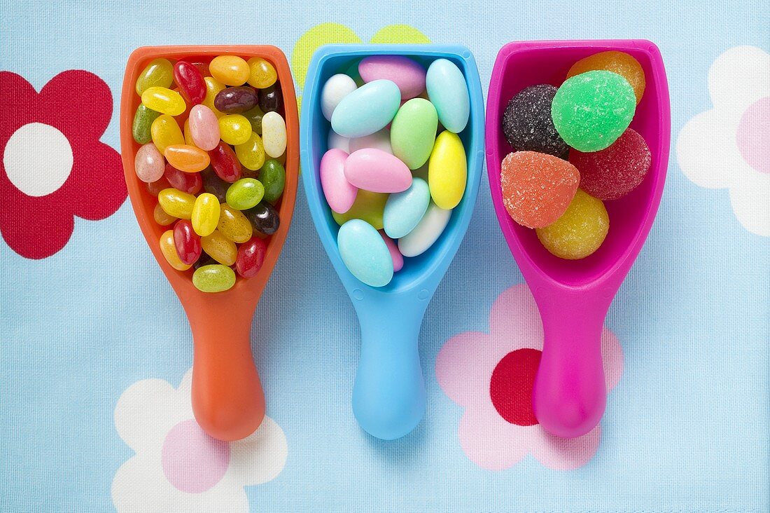 Assorted coloured sweets in plastic scoops