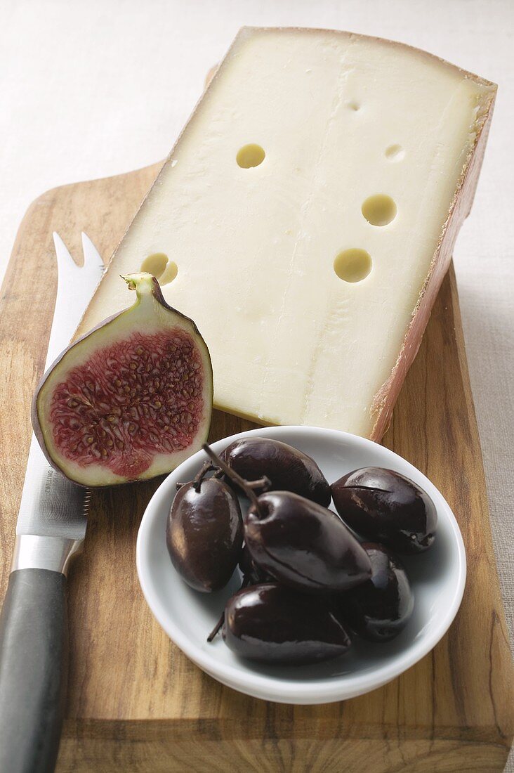 Piece of hard cheese, half a fig and olives