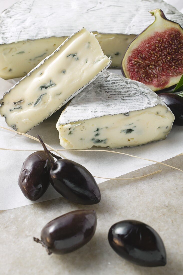 Blue cheese with pieces cut, half a fig and olives
