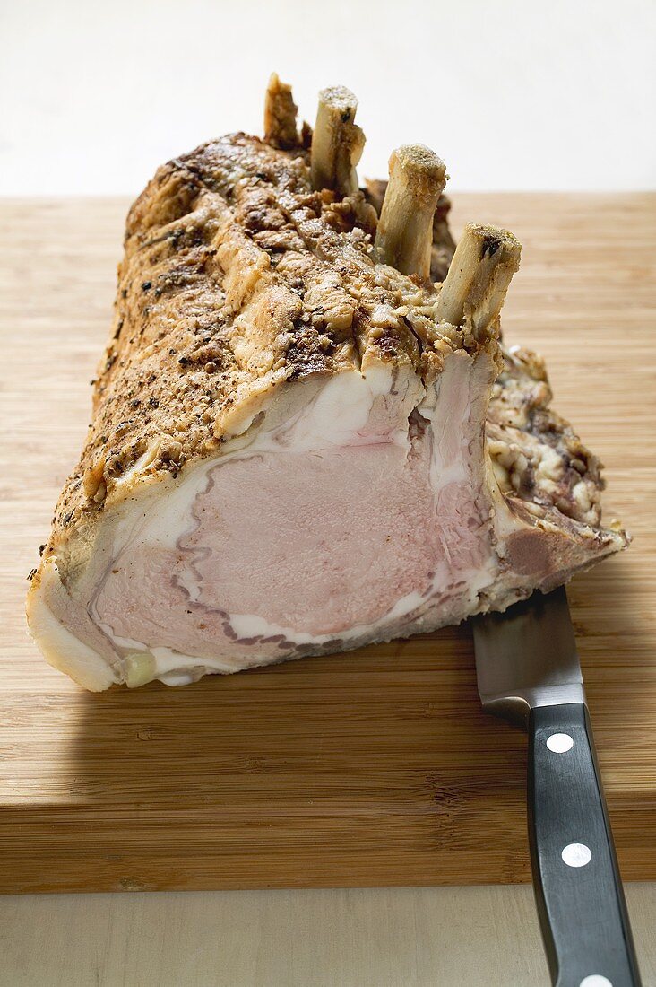 Rack of pork on chopping board with knife