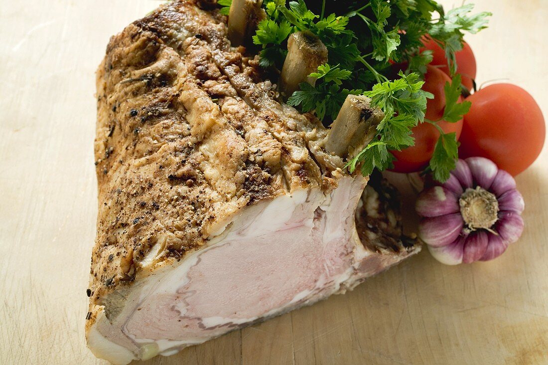 Rack of pork, garnished with parsley and fresh vegetables