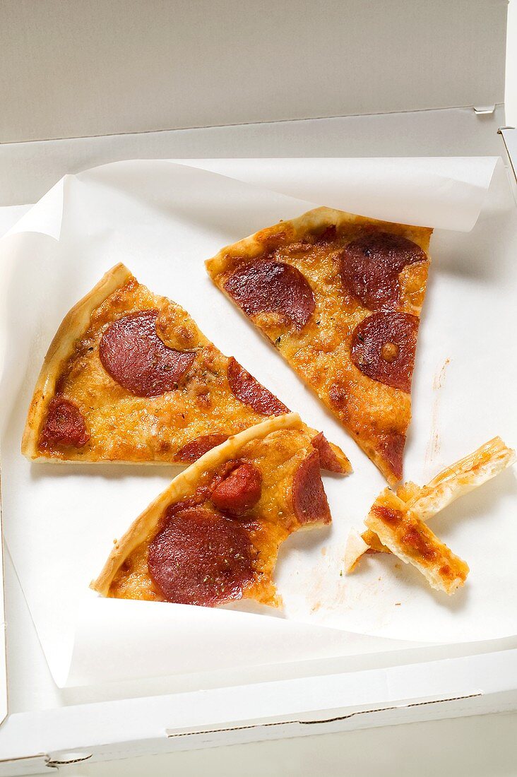 Three slices of pepperoni pizza in pizza box