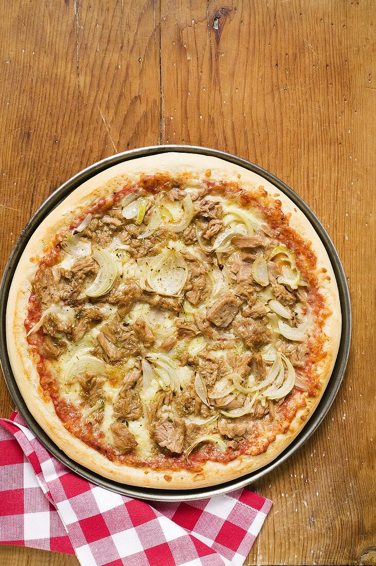 Tuna and onion pizza on wooden background
