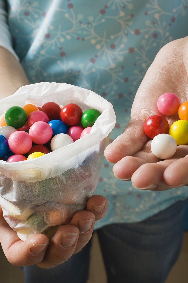 Hands holding coloured bubble gum balls