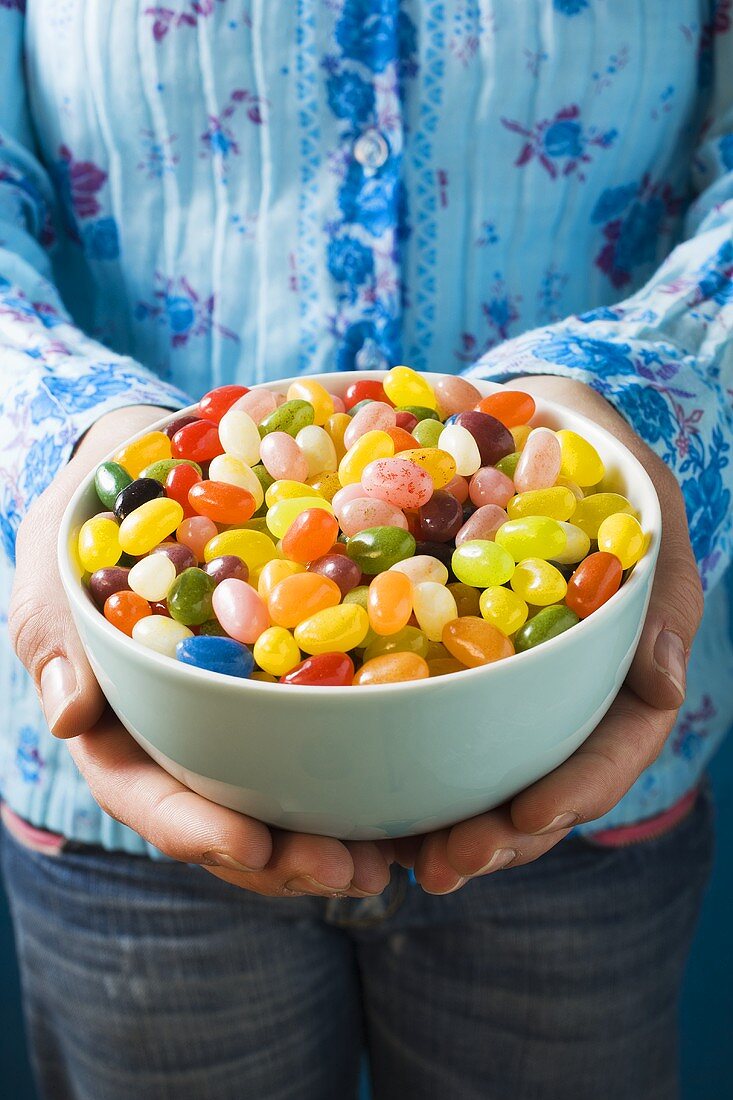 Hände halten Schüssel mit bunten Jelly Beans