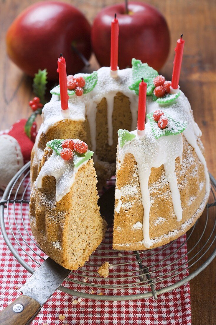 Weihnachtlicher Walnussgugelhupf, angeschnitten, mit Kerzen