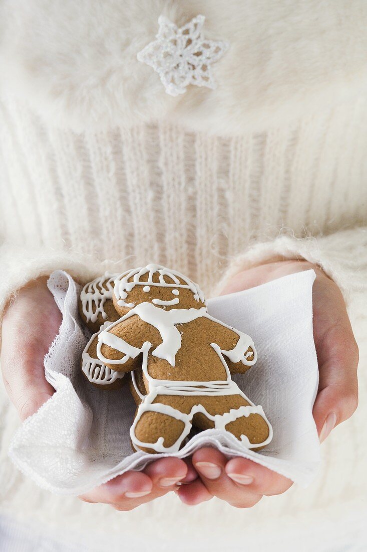 Hands holding two gingerbread men