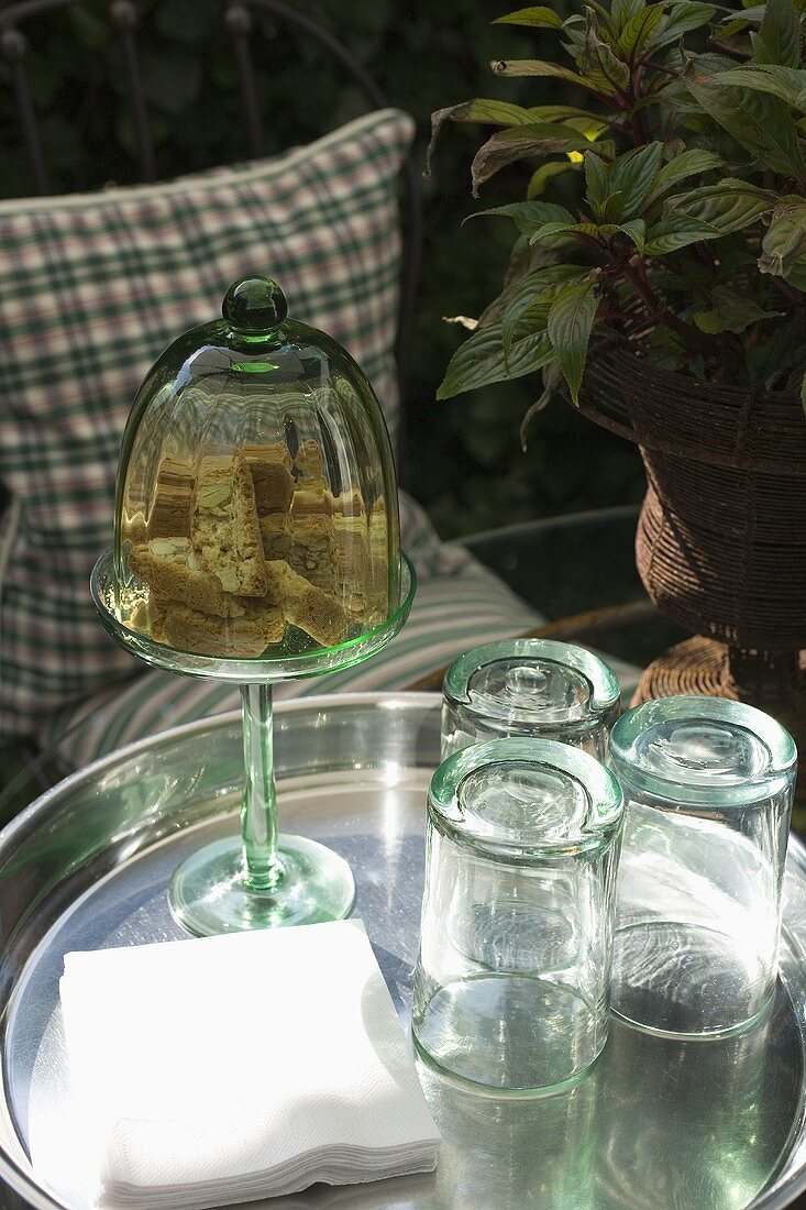 Cantuccini und leere Gläser auf Tablett im Freien