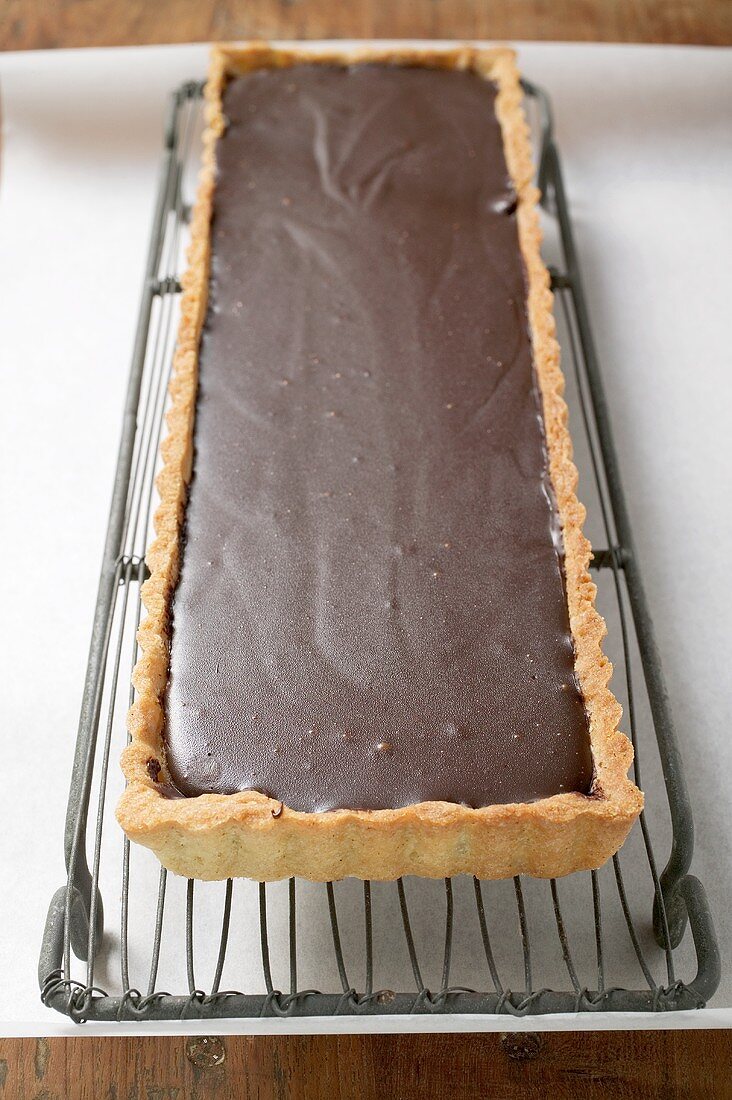 Rectangular chocolate tart on cake rack