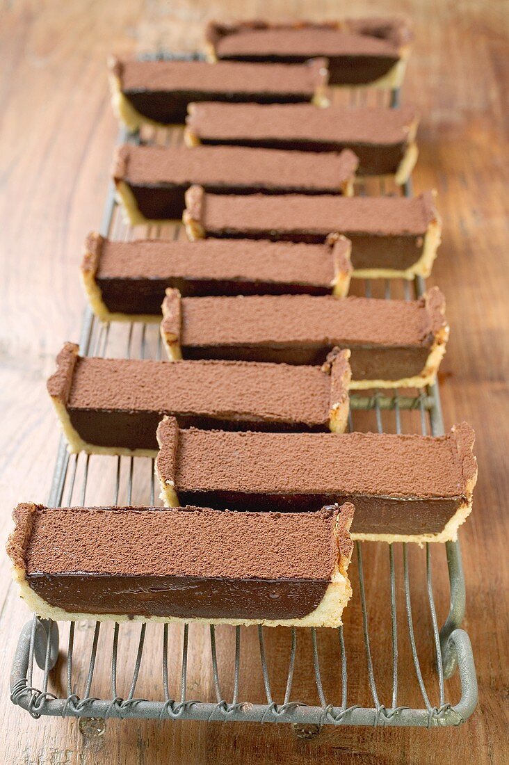 Rectangular chocolate tart with cocoa powder (in pieces)