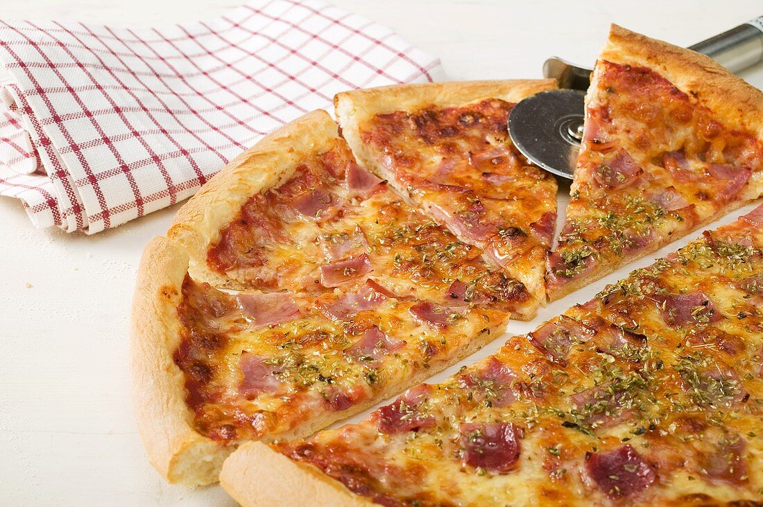 American-style ham pizza, cut into pieces