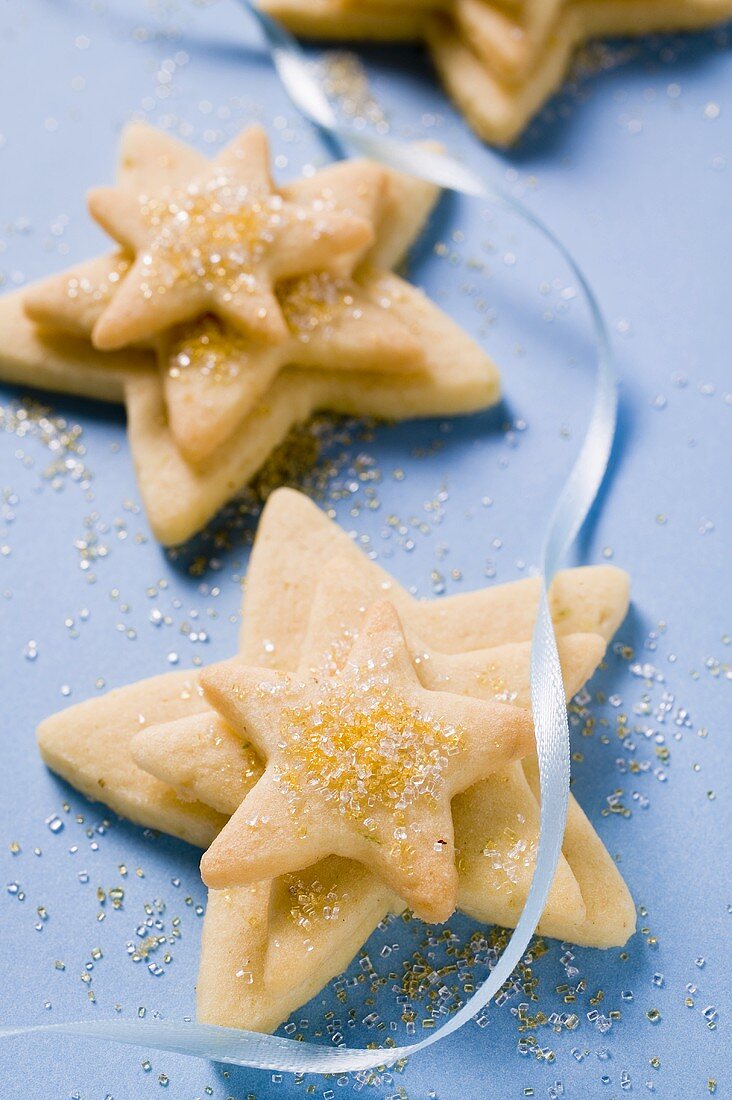 Mürbteigsterne mit Zucker und blauer Schleife