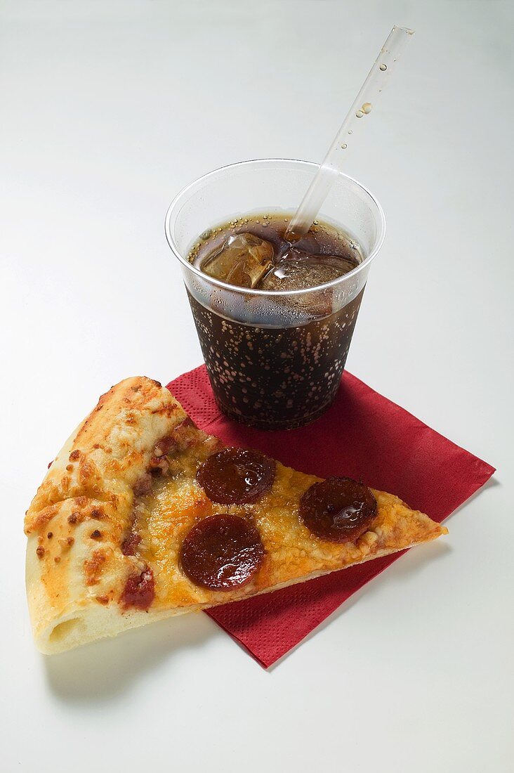 Slice of American-style pepperoni pizza with cola