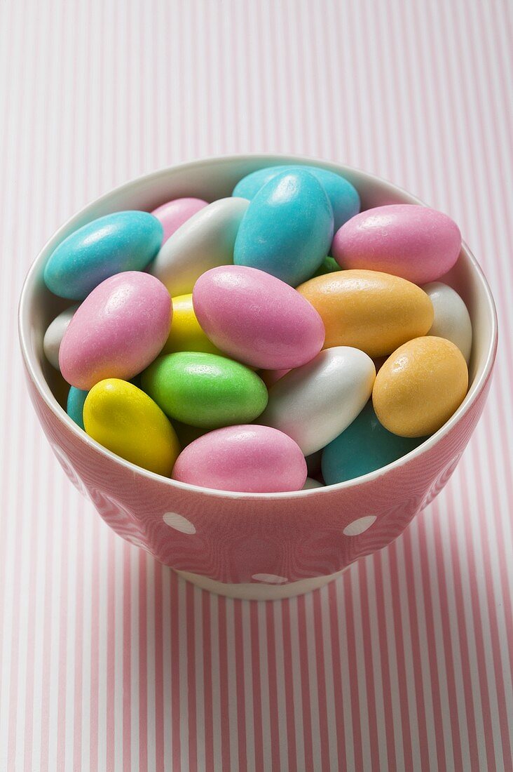 Coloured sugared almonds in pink bowl