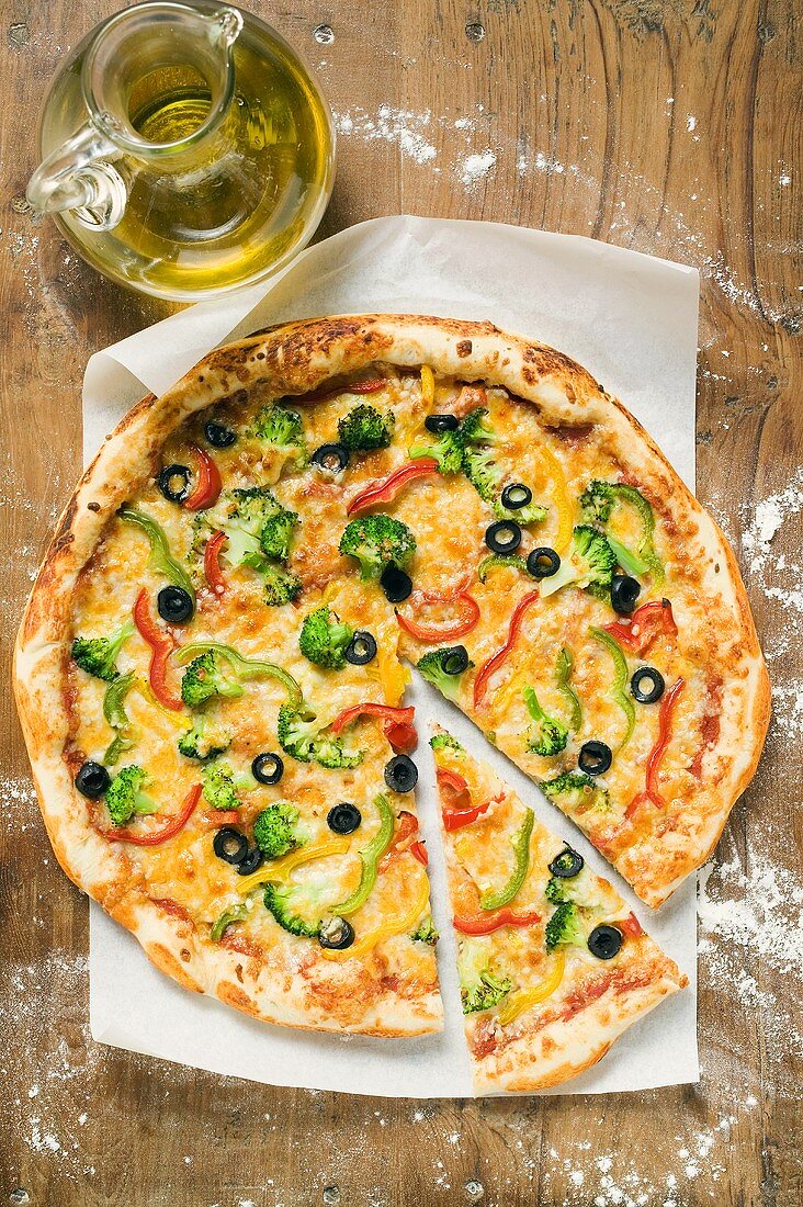 Gemüsepizza (amerikanische Art), angeschnitten, Olivenöl