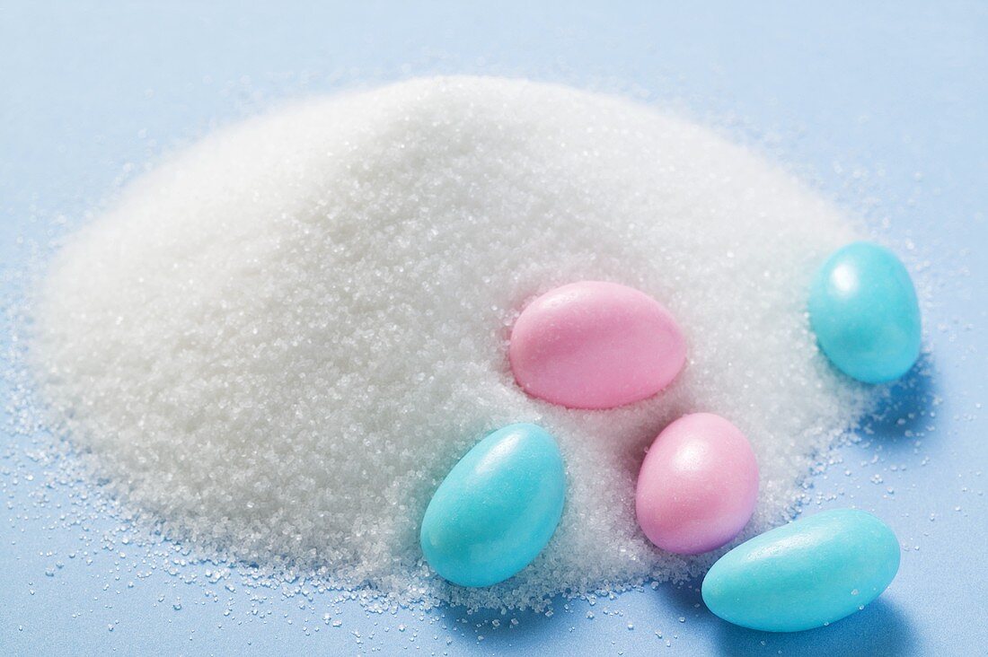 Coloured sugared almonds with a heap of sugar