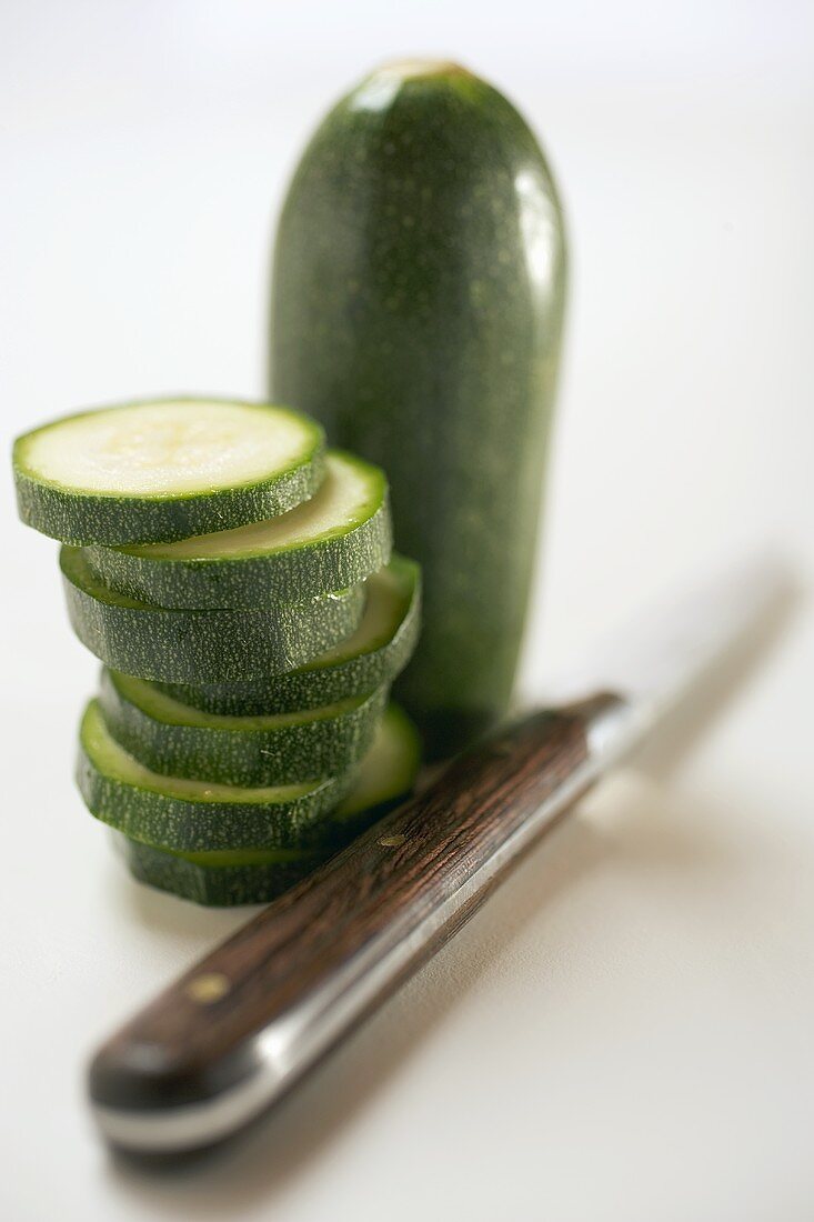 Courgette, partly sliced, with vegetable knife