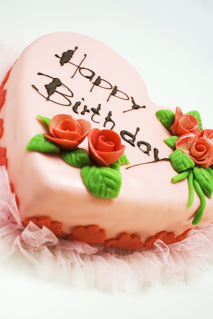 Pink heart-shaped birthday cake with marzipan roses