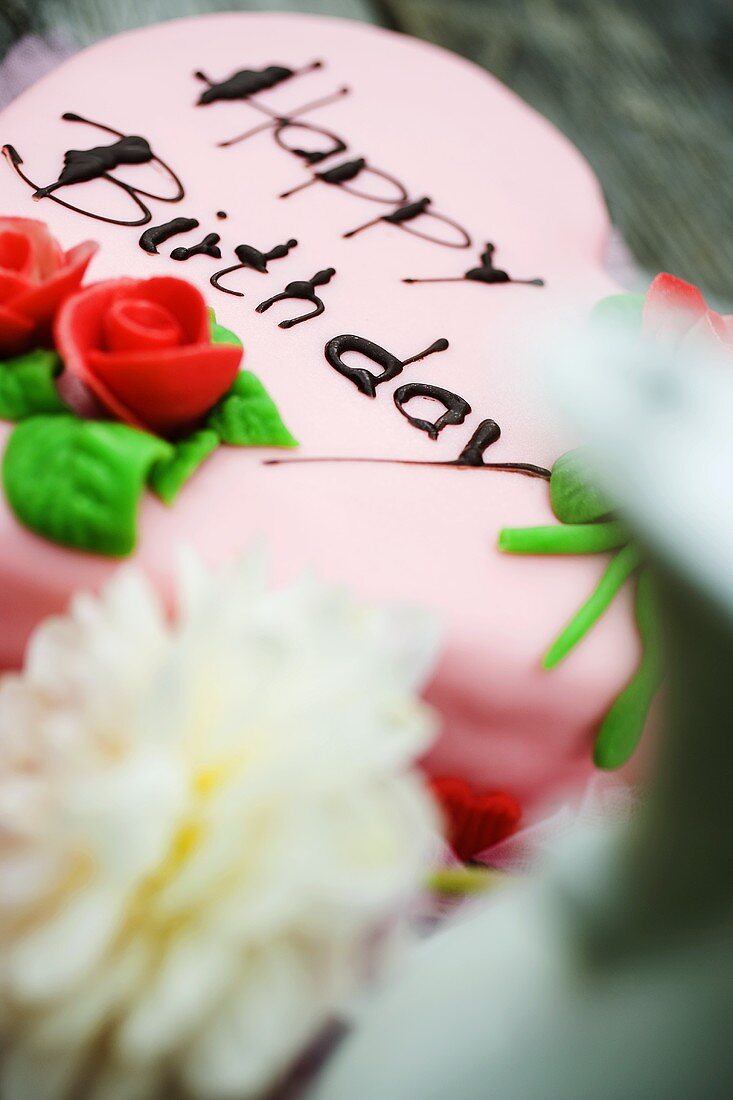 Herzförmige rosa Geburtstagstorte mit Marzipanrosen