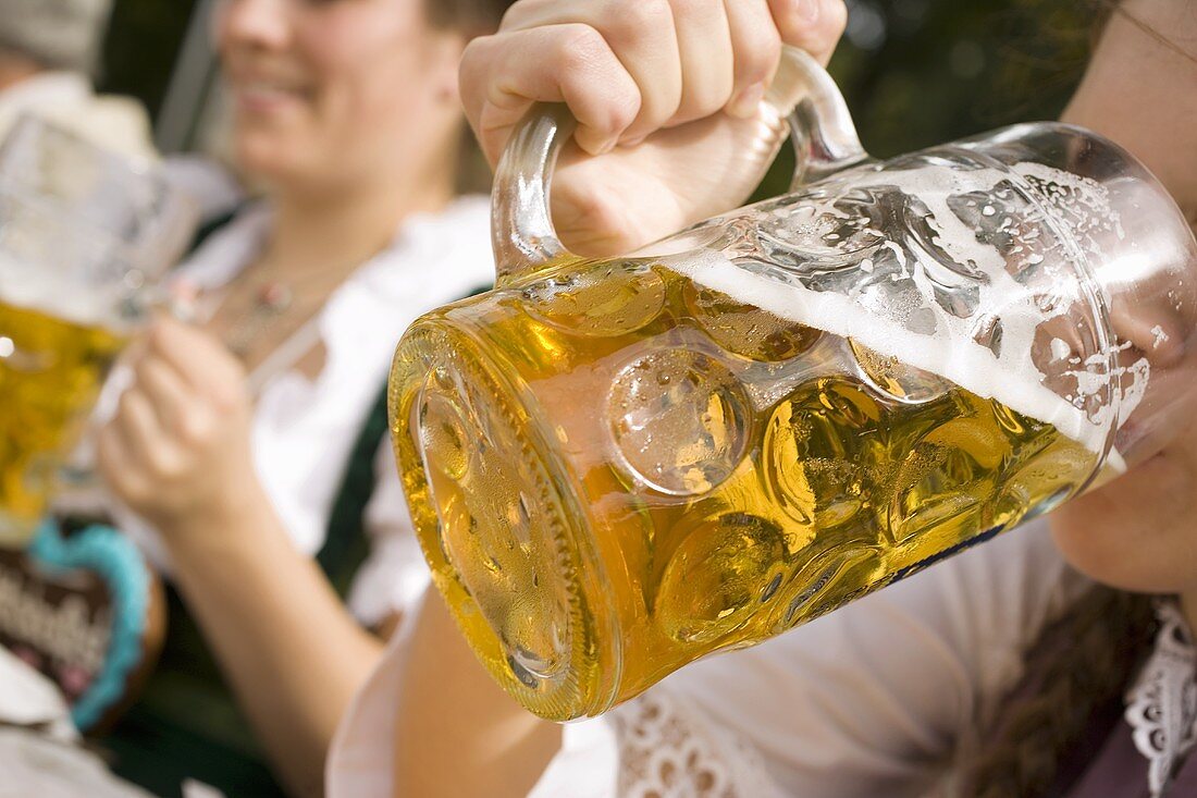 Frau trinkt Mass helles Bier (München, Oktoberfest)