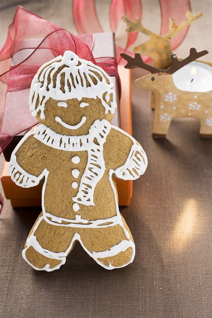 Gingerbread man in front of Christmas gifts