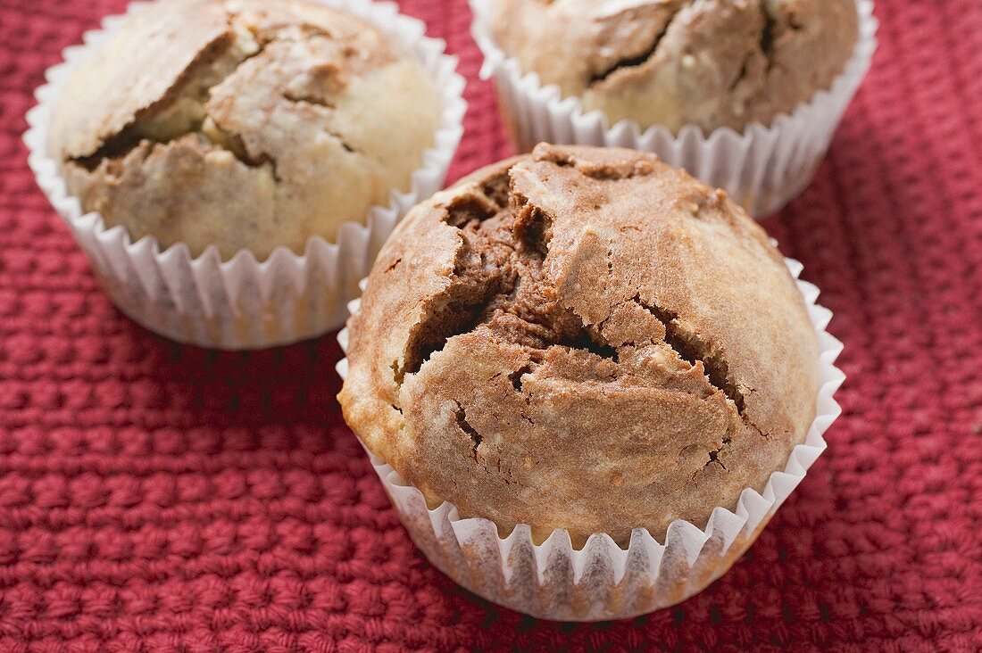 Three chocolate and vanilla muffins in paper cases