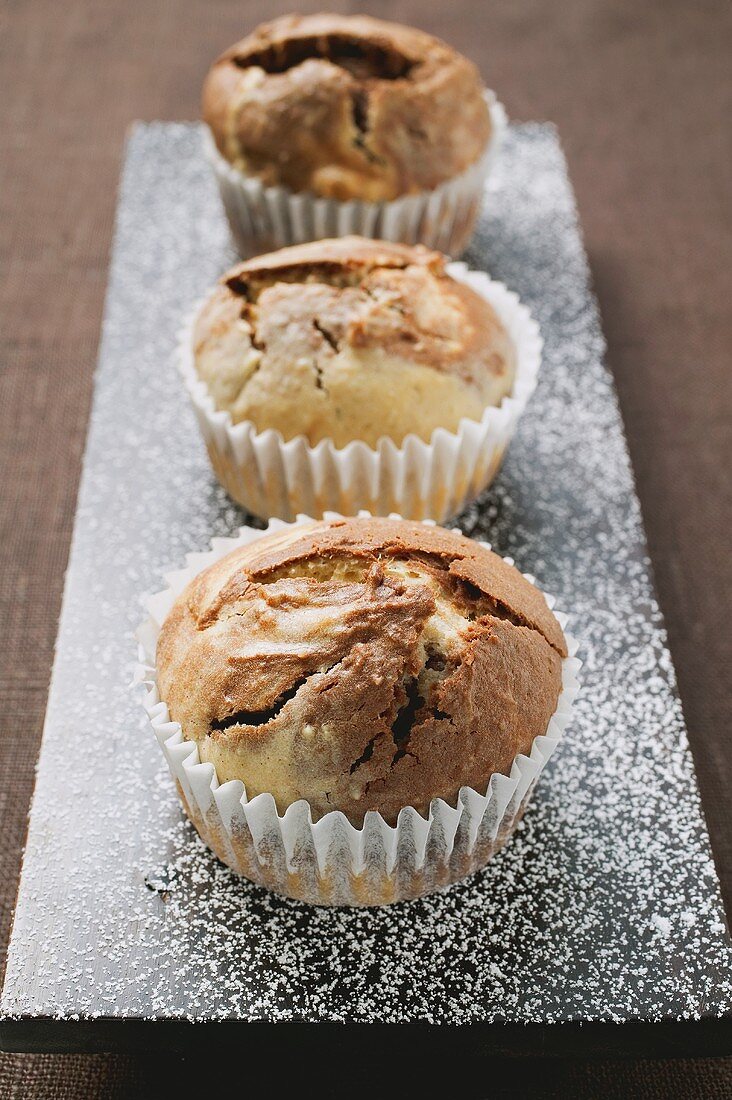 Three chocolate and vanilla muffins in paper cases