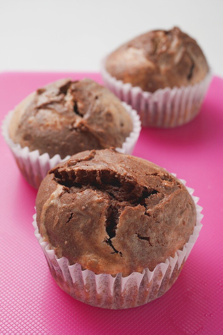 Three chocolate and vanilla muffins in paper cases