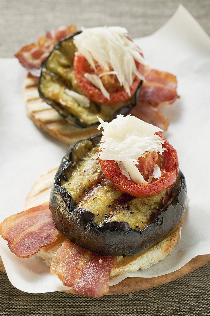 Toasts mit Bacon, gegrillter Aubergine, Tomate und Parmesan