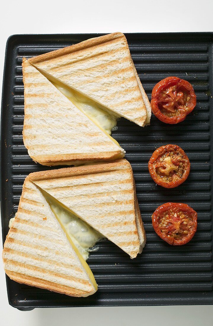 Käsetoasts und Tomaten auf Plattengrill