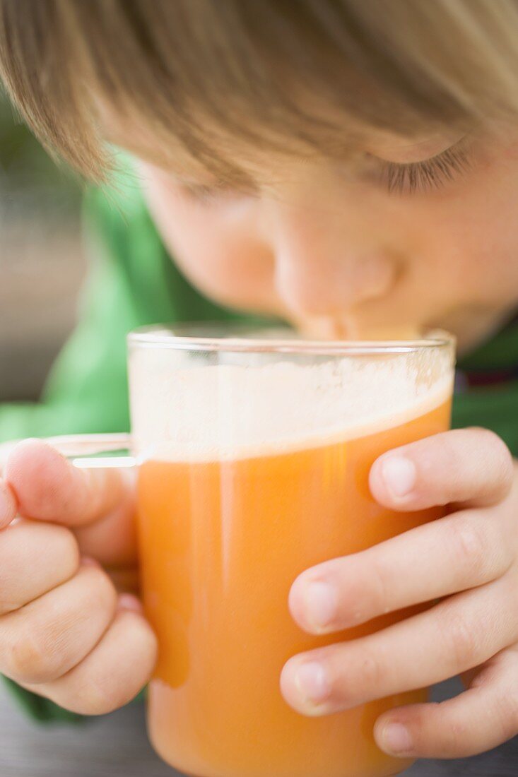 Kind trinkt Glas frisch gepressten Apfelsaft