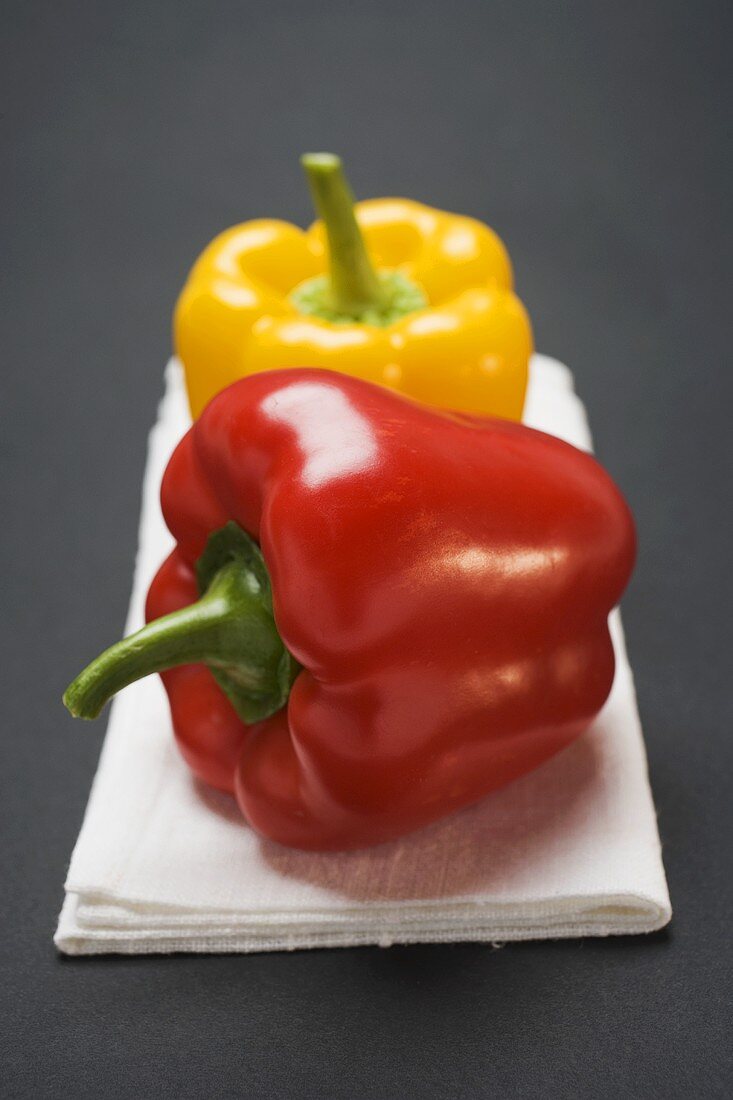 Two peppers (yellow, red) on white linen cloth