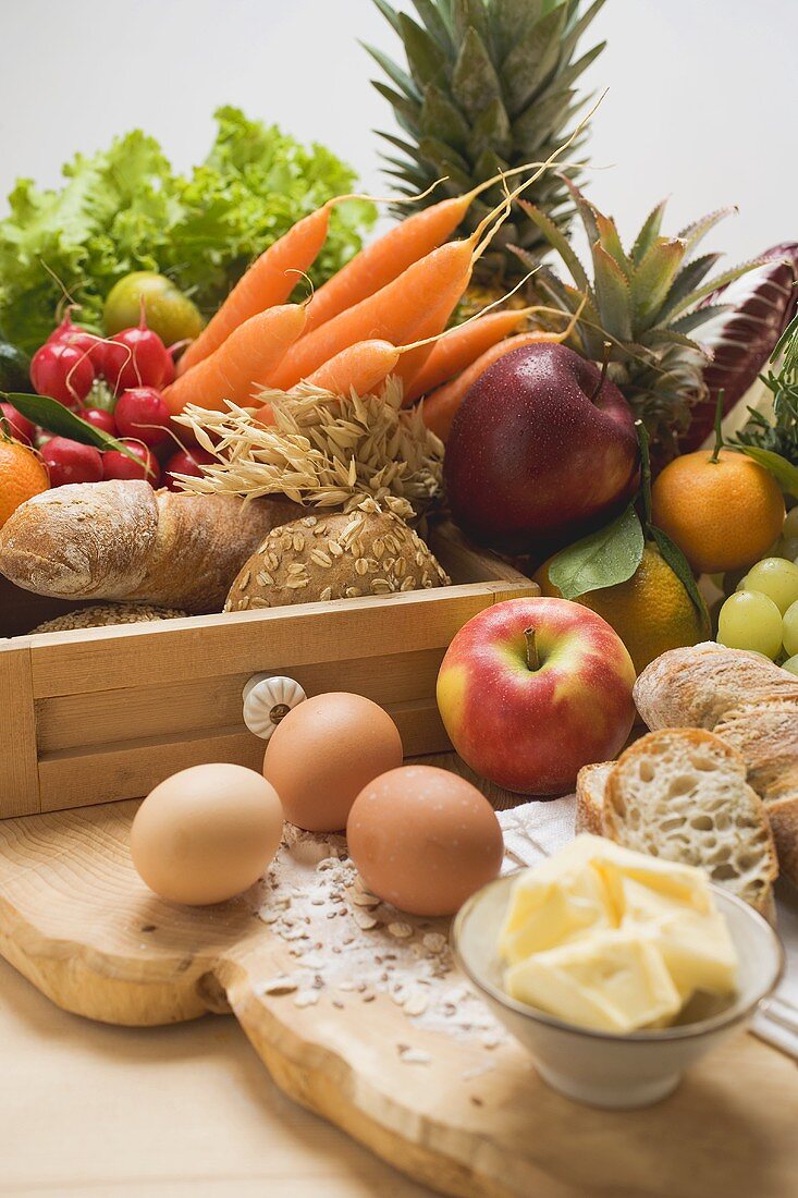 Stillleben mit Gemüse, Obst, Eiern, Butter und Vollwertbrot