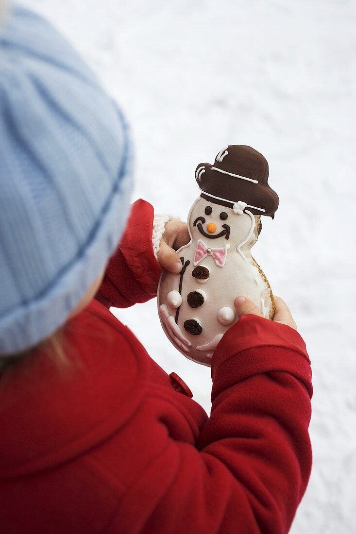 Kind hält Schneemannplätzchen