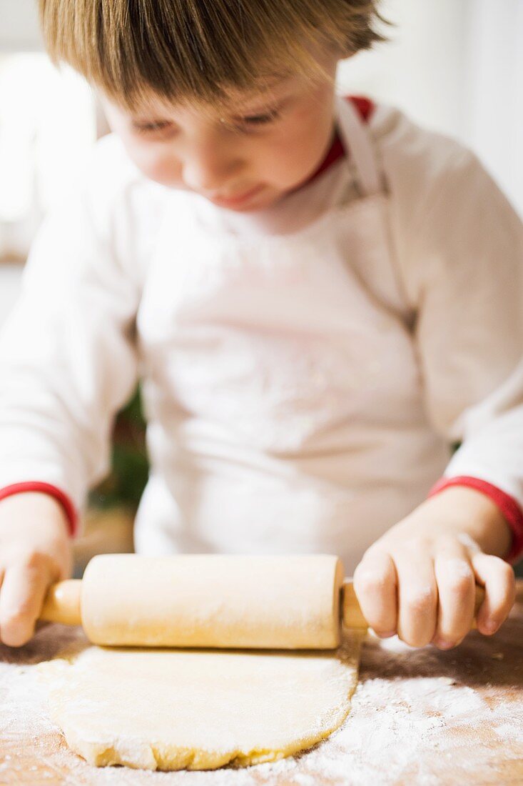 Small boy rolling out pastry