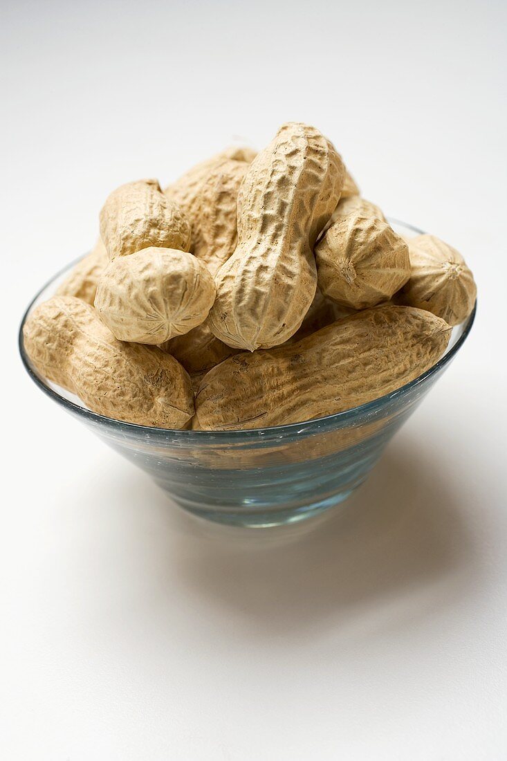 Several peanuts in glass bowl
