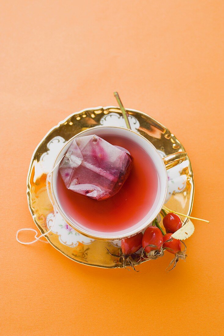 Rose hip tea with tea bag in china cup