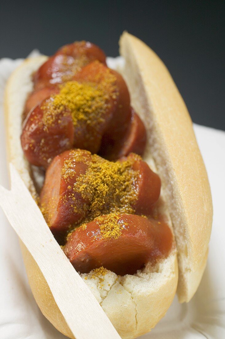 Currywurst im Brötchen auf Pappteller