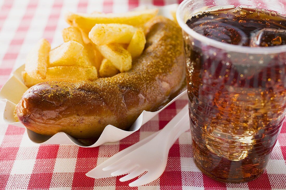 Currywurst mit Pommes frites und Cola im Restaurant