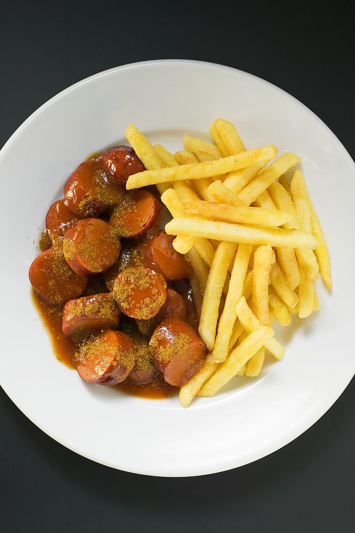 Currywurst (sausage with ketchup & curry powder) & chips on plate