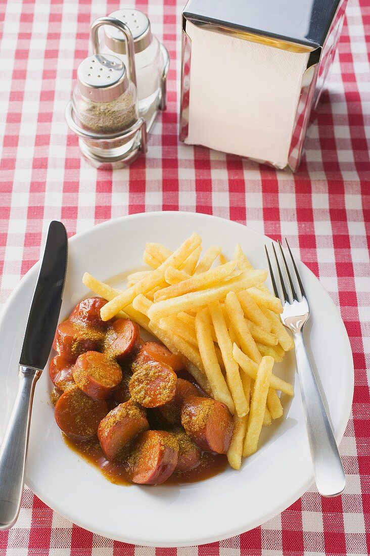 Currywurst mit Ketchup und Pommes frites im Restaurant