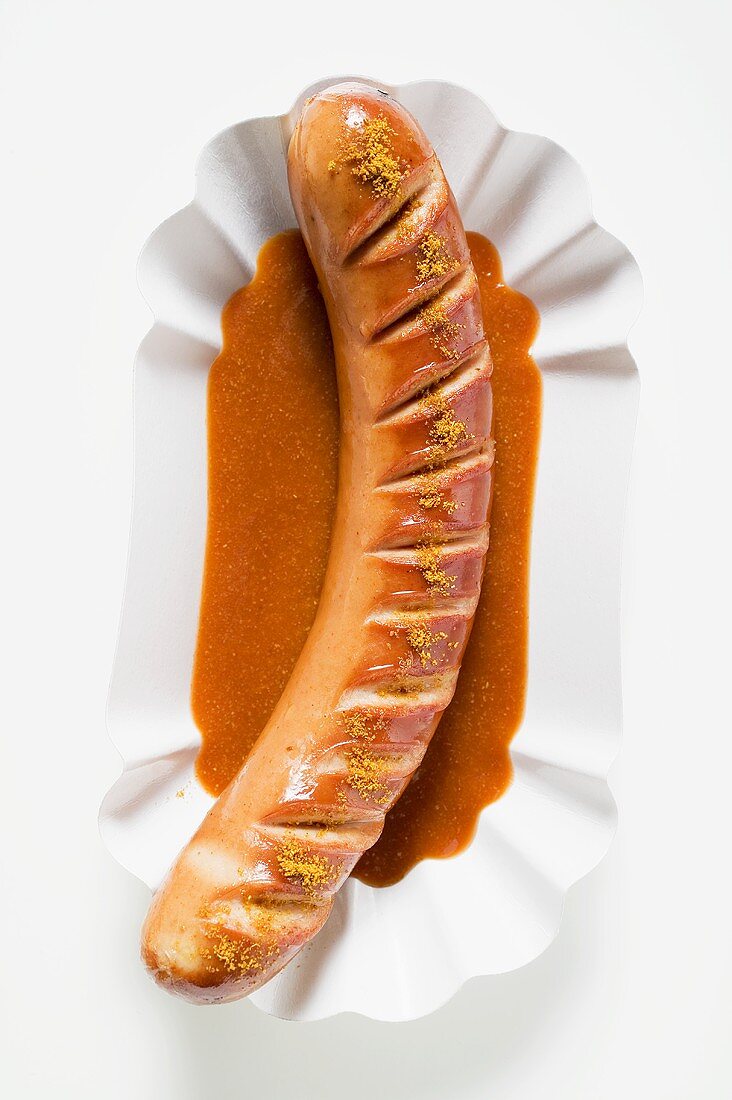 Currywurst mit Ketchup auf Pappteller