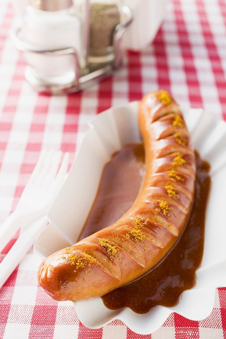 Currywurst mit Ketchup auf Pappteller im Restaurant